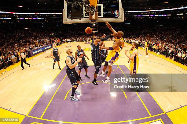 Kobe Bryant of the Los Angeles Lakers dunks over C.J. Miles of the Utah Jazz in the fourth quarter during Game Two of the Western Conference...