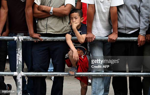 Nepalese child watches as Maoist cadres sing and dance during the fourth day of an indefinite nationwide strike in Kathmandu on May 5, 2010. All...