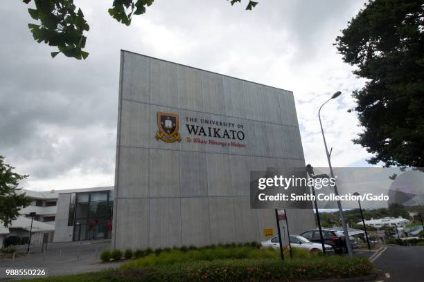 Sign with campus buildings in background at the University of Waikato in Hamilton, New Zealand on an overcast day, November, 2017.