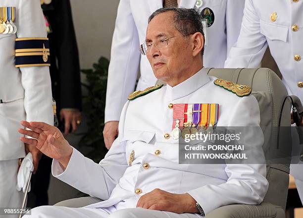 Thai King Bhumibol Adulyadej waves to a crowd of well-wishers as he marks the 60th anniversary of his coronation in Bangkok on May 5, 2010. The...