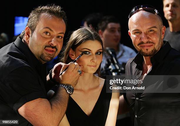 Napoleon Perdis prepares a model backstage as Alex Perry looks on ahead of the Alex Perry show on the second day of Rosemount Australian Fashion Week...