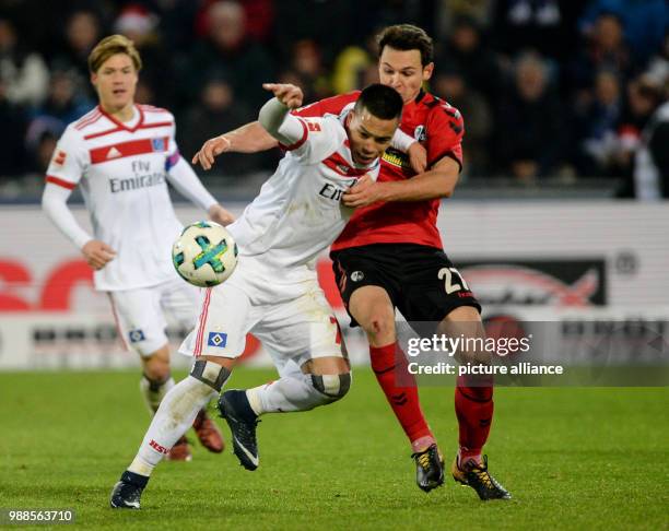 Hamburg's Bobby Wood and Freiburg's Nicolas Hoefler vie for the ball during the German Bundesliga soccer match between SC Freiburg and Hamburger SV...