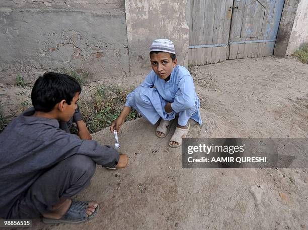 To go with US-attacks-Pakistan-Shahzad,PROFILE by Sajjad Tarakzai Pakistani local youths eat food in front of the locked residence of...