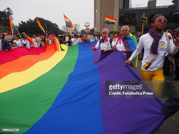 Giant gay flag is carried through the streets when thousands of activists from the LGBT community and sympathizers take to the street to participate...