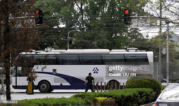 Policemen attempt to use a police bus to block the street in front of Diaoyutai State Guest House as a diplomactic motorcade arrives in Beijing on...