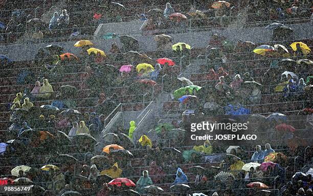Spectators watch the Spanish League football match Barcelona against Tenerife under the rain at the Camp Nou stadium in Barcelona on May 4, 2010....