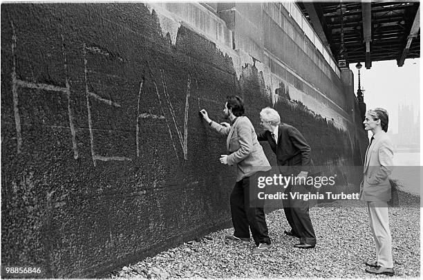 Martyn Ware, Glenn Gregory and Ian Craig Marsh of Heaven 17 scratch the band name into the wall by the Thames at Embankment on March 31st 1981 in...