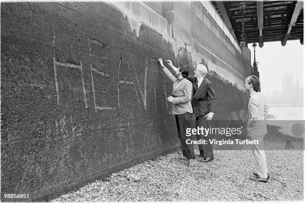 Martyn Ware, Glenn Gregory and Ian Craig Marsh of Heaven 17 scratch the band name into the wall by the Thames at Embankment on March 31st 1981 in...