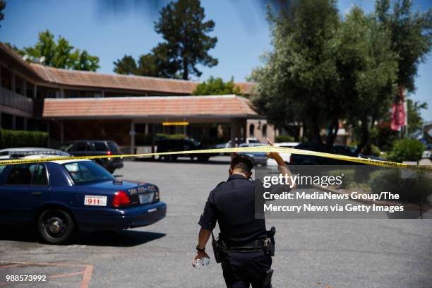 San Jose Police Department officer walks to an apartment complex on June 28, 2018 in San Jose. A primary suspect in the notorious ritualistic killing...