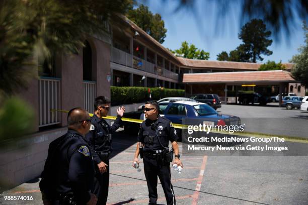 San Jose Police Department officers talk at an apartment complex on June 28, 2018 in San Jose. A primary suspect in the notorious ritualistic killing...