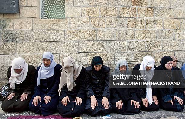 Palestinian women pray near the Lion's Gate in Jerusalem's old city during clashes between Palestinian stone-throwers and Israeli police near the...