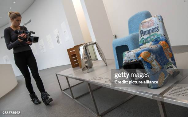 Camera woman films children's chairs at the exhibition ""...only chairs? Children's chairs from Sammlung Neuwald" hosted by the Pinakothek der...