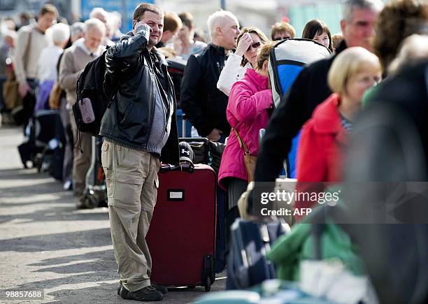 Passengers queue to board coaches for other airports, after their flights were cancelled due to the volcanic ash cloud re-entering the UK's airspace,...