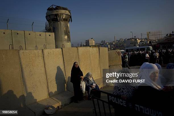 Palestinian Muslim worshippers wait to cross through the West Bank Israeli checkpoint of Qalandia into Jerusalem to attend the second Ramadan Friday...