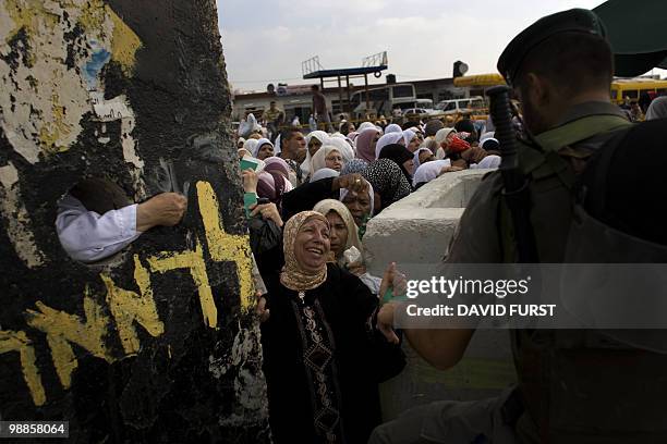 Palestinian Muslim worshippers plead with Israeli soldiers to allow them to cross through the West Bank checkpoint of Qalandia into Jerusalem to...