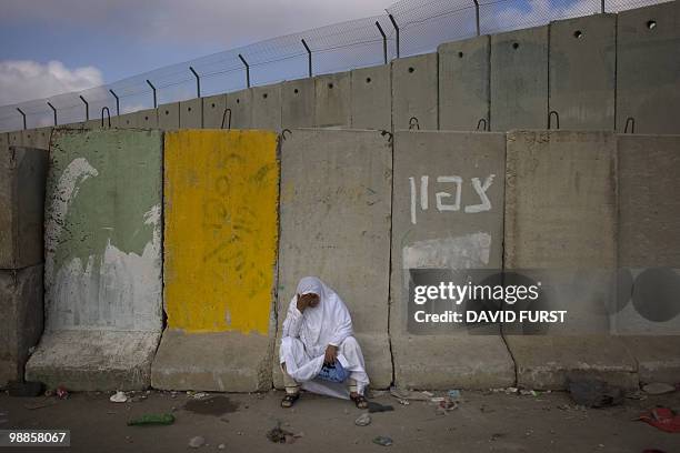 Palestinian Muslim worshipper takes a moment to rest after struggling to cross through the West Bank Israeli checkpoint of Qalandia into Jerusalem to...