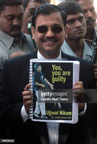 Special Prosecutor Ujjwal Nikam shows a copy of the verdict to the media outside the Arthur Road Jail, where the trial of Mohammad Ajmal Kasab, the...