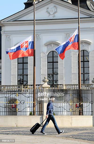 Man walks past Slovakian flags flying at half mast in front of the Presidential palace in Bratislava on April 18, 2010. The bodies of Polish...