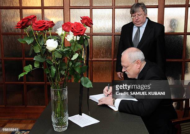 Slovak President Ivan Gasparovic signs the book of condolences next to Polish Ambassador Andrzej Krawczyk at the Polish embassy in Bratislava on...