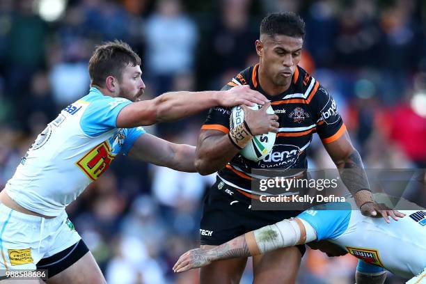 Michael Chee Kam of the Tigers is is tackled by Titans defense during the round 16 NRL match between the Wests Tigers and the Gold Coast Titans at...