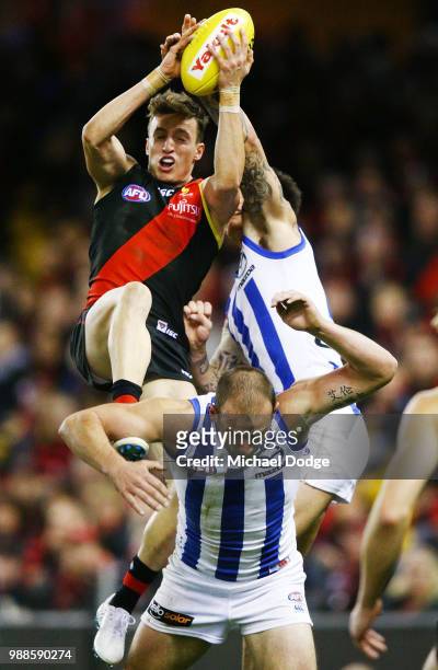 Orazio Fantasia of the Bombers competes for the ball over Ben Cunnington of the Kangaroos during the round 15 AFL match between the Essendon Bombers...