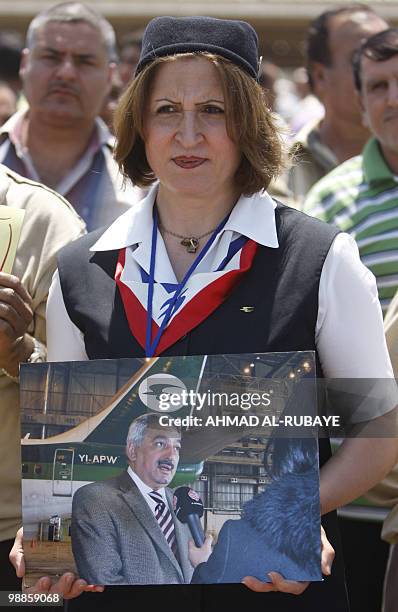 An Iraqi Airways hostess holds a picture of the airline's chief executive Kifah Hassan Jabbar during a demonstration at Baghdad airport on May 5,...