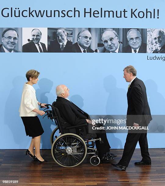 Former German Chancellor Helmut Kohl is pushed by his wife Meike Kohl-Richter as he looks together with German President Horst Koehler at pictures of...