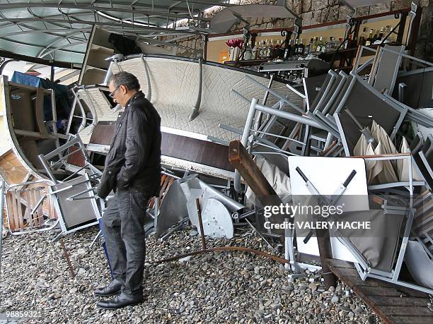 Man passe next to the damaged beach-shore cafe "Castel Plage" after the big waves break, on May 5, 2010 in Nice, southeastern France, 24 hours after...