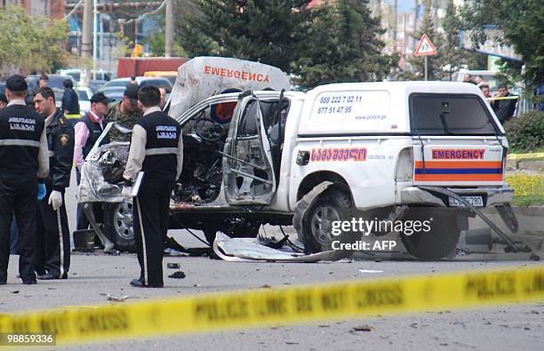 Georgian police stand near the blown-up automobile of local Emergency Services head Dmitry Kordzaya in Batumi on May 5, 2010. Investigators are...