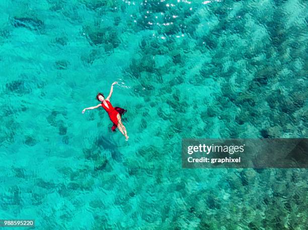 woman floating and swimming on a tropical sea - lagoon stock pictures, royalty-free photos & images