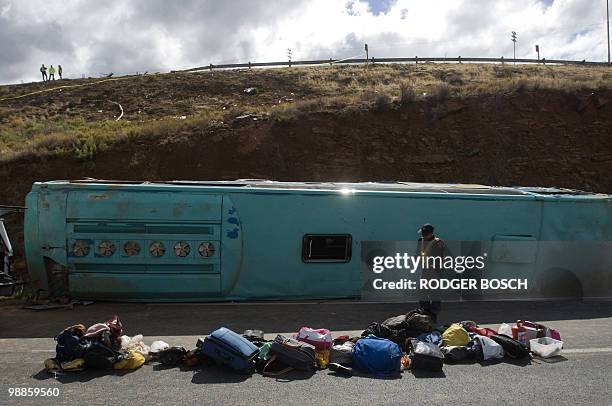 South African policemen remove personal effects on the site of a bus accident on the N1 on May 05, 2010 between De Doorns and Touws river some 150...