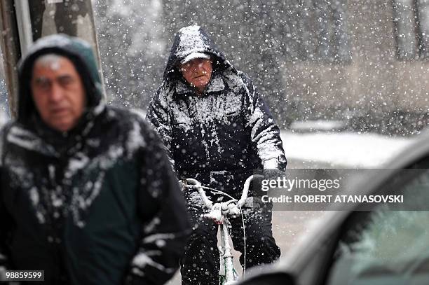 Man rides a bicycle on the streets of Skopje during the snow falls on March 8, 2010. Heavy snow fall and low temperatures have hit the Balkan...