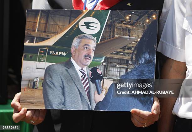 An Iraqi Airways hostess holds a picture of the airline's chief executive Kifah Hassan Jabbar during a demonstration at Baghdad airport on May 5,...