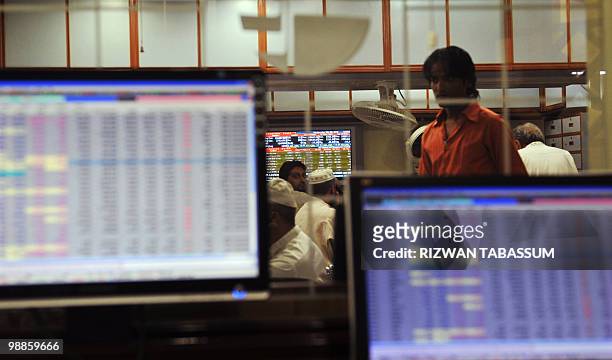 Pakistani stockdealers monitor stock prices at a brokerage houses in Karachi on May 5, 2010. The benchmark Karachi Stock Exchange 100 index was...