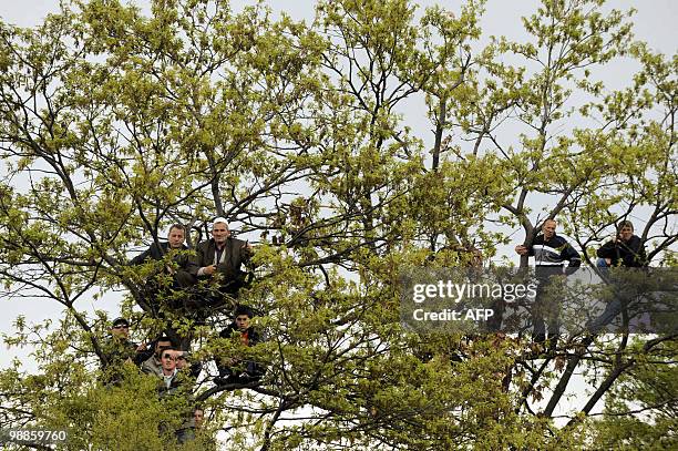 Kosovo Albanians watch from the tree as they attend a ceremony on April 25 in the village of Vermnice of a multi-million euro highway as the biggest...