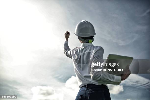 businesswoman in hardhat holding laptop outdoors - architect in landscape stock pictures, royalty-free photos & images