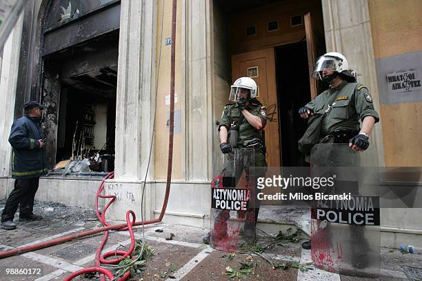 Greek riot police secure the entrance of the Marfin Egnatia Bank where 3 people died after protesters set fire to the building, on May 5, 2010 in...