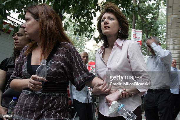 Marfin Egnatia Bank employees look on at the scene where 3 people died after protesters set fire to the building, on May 5, 2010 in Athens, Greece....