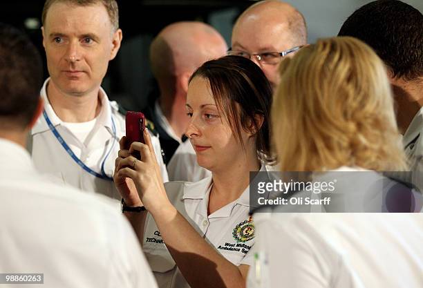 An ambulance worker uses her mobile phone to take a photograph of David Cameron, the leader of the Conservative party, during his visit to Dudley...