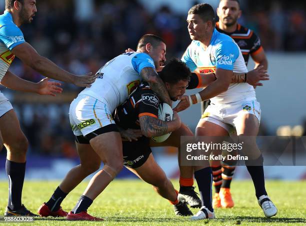 Josh Aloisi of the Tigers is tackled by Titans defense during the round 16 NRL match between the Wests Tigers and the Gold Coast Titans at Leichhardt...