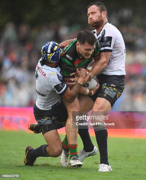 Angus Crichton of the Rabbitohs is tackled by Johnathan Thurston and Gavin Cooper of the Cowboys during the round 16 NRL match between the South...
