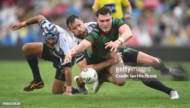 Angus Crichton of the Rabbitohs loses the ball after being tackled by Johnathan Thurston and Gavin Cooper of the Cowboys during the round 16 NRL...