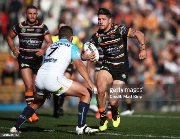 Malakai Watene-Zelezniak of the Tigers takes on the defence during the round 16 NRL match between the Wests Tigers and the Gold Coast Titans at...