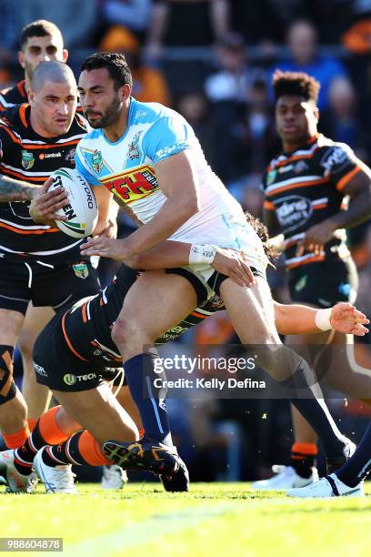 Ryan James of the Titans is tackled by Tigers defense during the round 16 NRL match between the Wests Tigers and the Gold Coast Titans at Leichhardt...