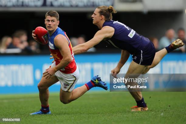 Dayne Zorko of the Lions avoids being tackled by Nathan Fyfe of the Dockers during the round 15 AFL match between the Fremantle Dockers and the...