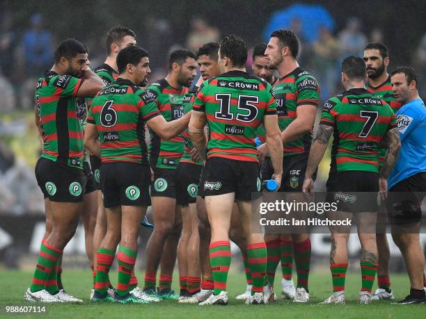 The Rabbitohs stand together in a huddle during the round 16 NRL match between the South Sydney Rabbitohs and the North Queensland Cowboys at Barlow...