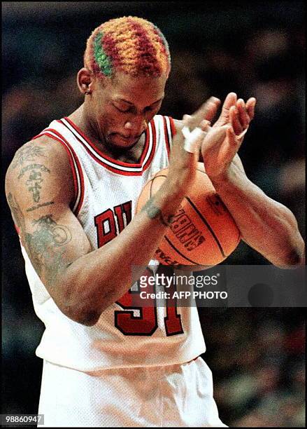 Chicago Bulls forward Dennis Rodman claps at the free throw line after making a free throw that sealed the Bulls' victory against the Los Angeles...