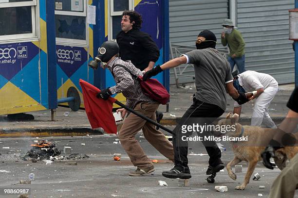 Protesters throw missles at Greek riot police as they clash on May 5, 2010 in Athens, Greece. Three people have died after protesters set fire to the...