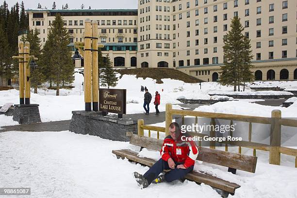 Man takes a break on a park bench at the Fairmont Chateau Lake Louise Hotel as seen in this 2010 Lake Louise, Canada, late morning photo. The resort...