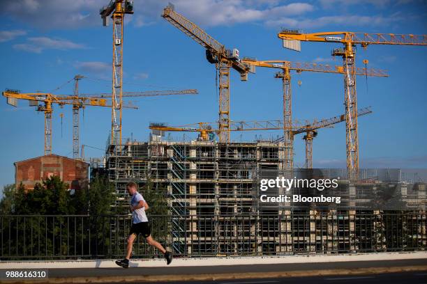 Construction cranes stand above the Europacity project residential building site in Berlin, Germany, on Wednesday, June 27, 2018. In a...